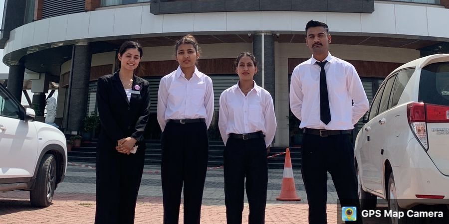 Four hotel management trainees in uniform outside the Regenta Place hotel, Mohali, after placement