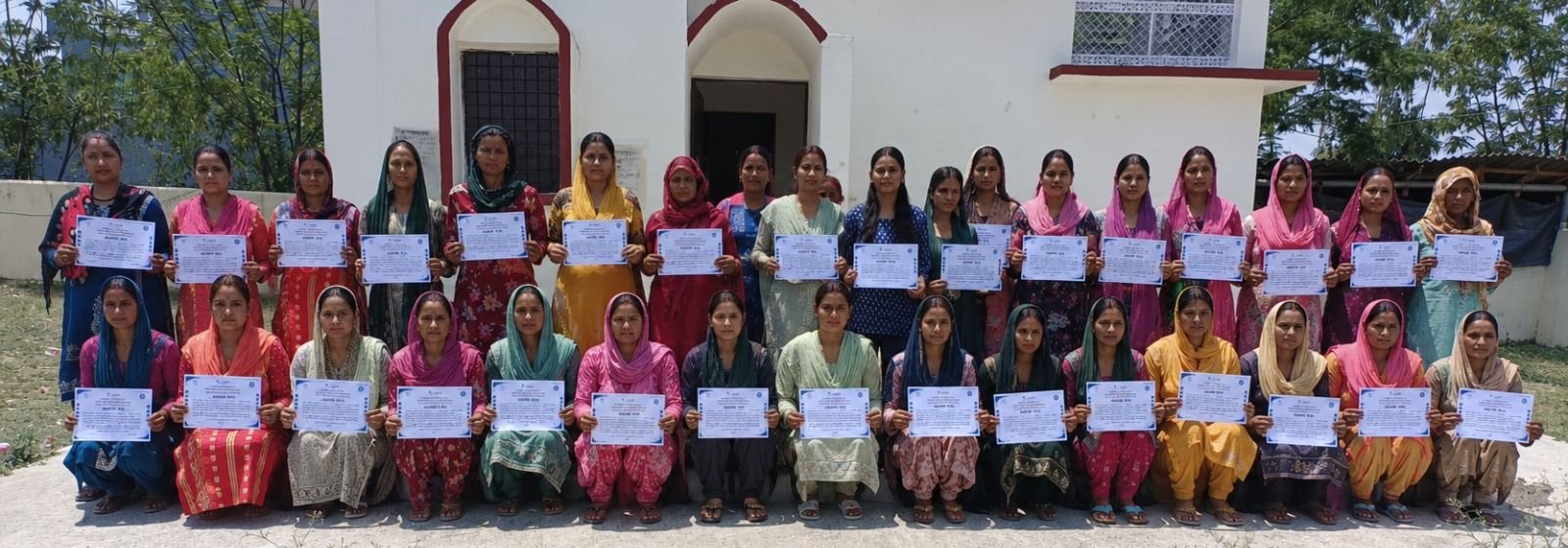 Trainees of a women's skill batch holding their completion certificates at Sherpur, Dehradun